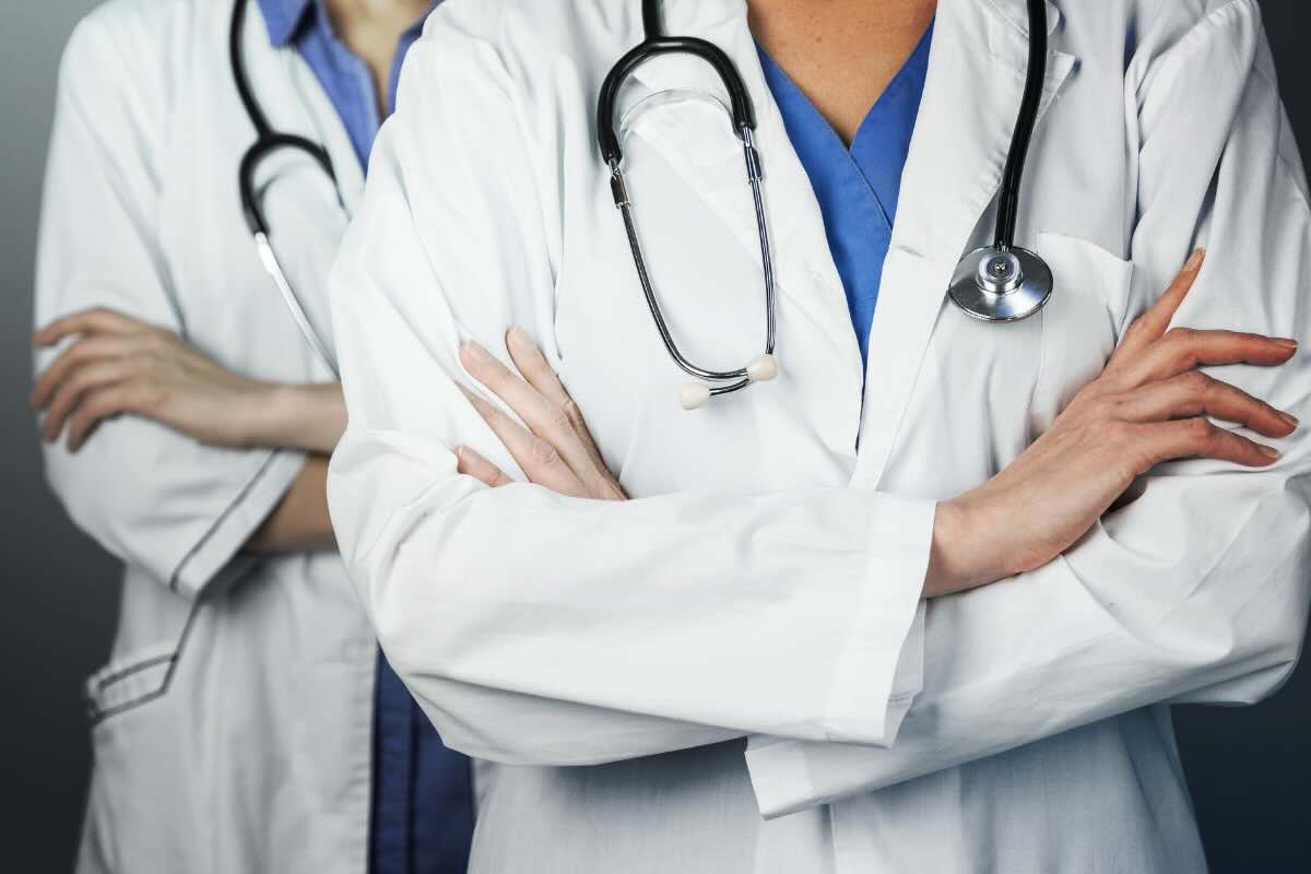 due persone con braccia conserte e camici da dottore